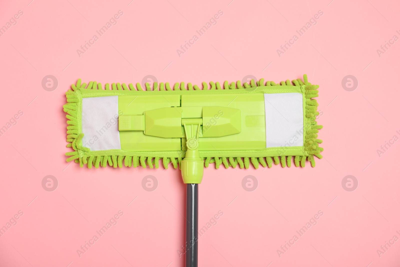 Photo of Microfiber mop on pink background, top view