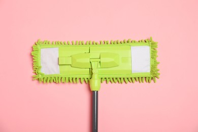 Photo of Microfiber mop on pink background, top view