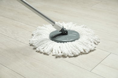 Photo of String mop on wooden floor. Cleaning equipment