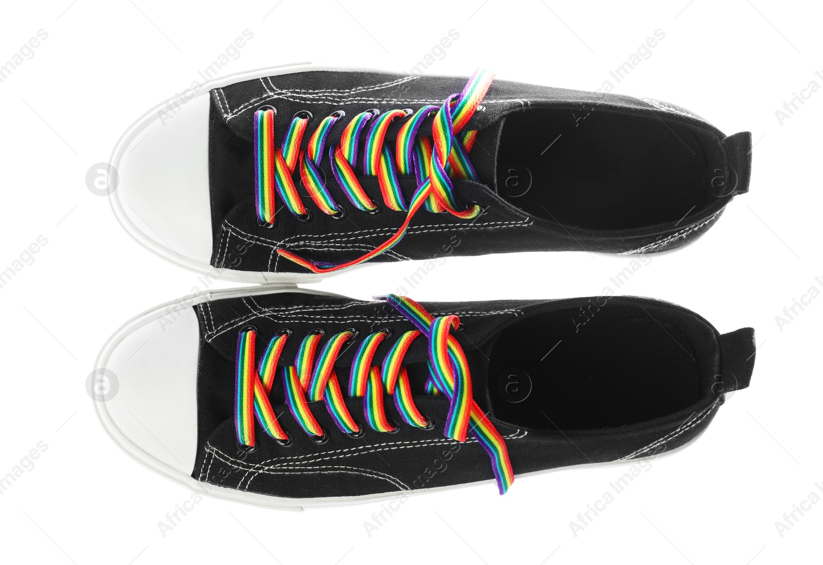 Photo of Black shoes with bright rainbow laces on white background, top view. LGBT concept