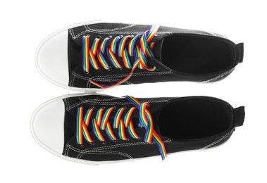 Photo of Black shoes with bright rainbow laces on white background, top view. LGBT concept