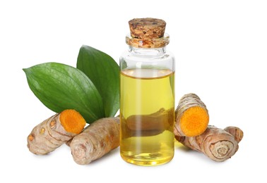 Photo of Bottle of turmeric essential oil, raw roots and leaves isolated on white