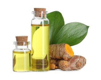 Photo of Bottles of turmeric essential oil, raw roots and leaves isolated on white