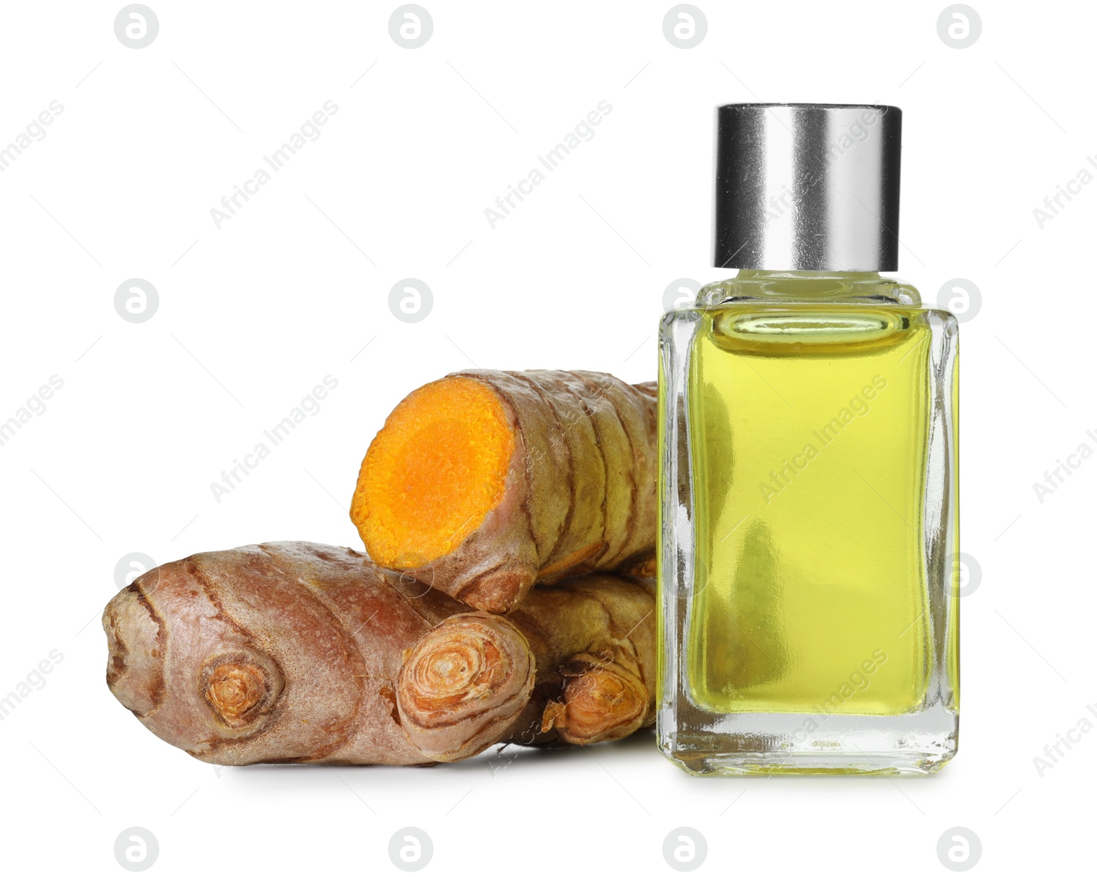 Photo of Bottle of turmeric essential oil and raw roots isolated on white