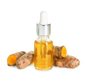 Photo of Bottle of turmeric essential oil and raw roots isolated on white