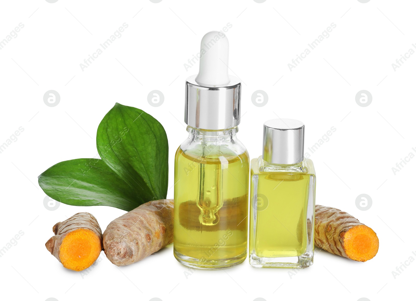 Photo of Bottles of turmeric essential oil, raw roots and leaves isolated on white