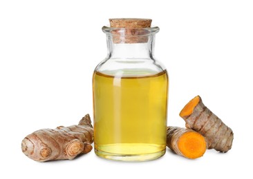 Photo of Bottle of turmeric essential oil and raw roots isolated on white