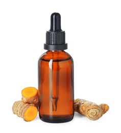 Photo of Bottle of turmeric essential oil and raw roots isolated on white