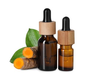 Photo of Bottles of turmeric essential oil, raw roots and leaves isolated on white