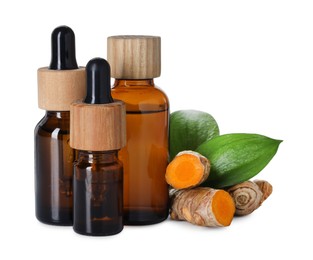 Photo of Bottles of turmeric essential oil, raw roots and leaves isolated on white