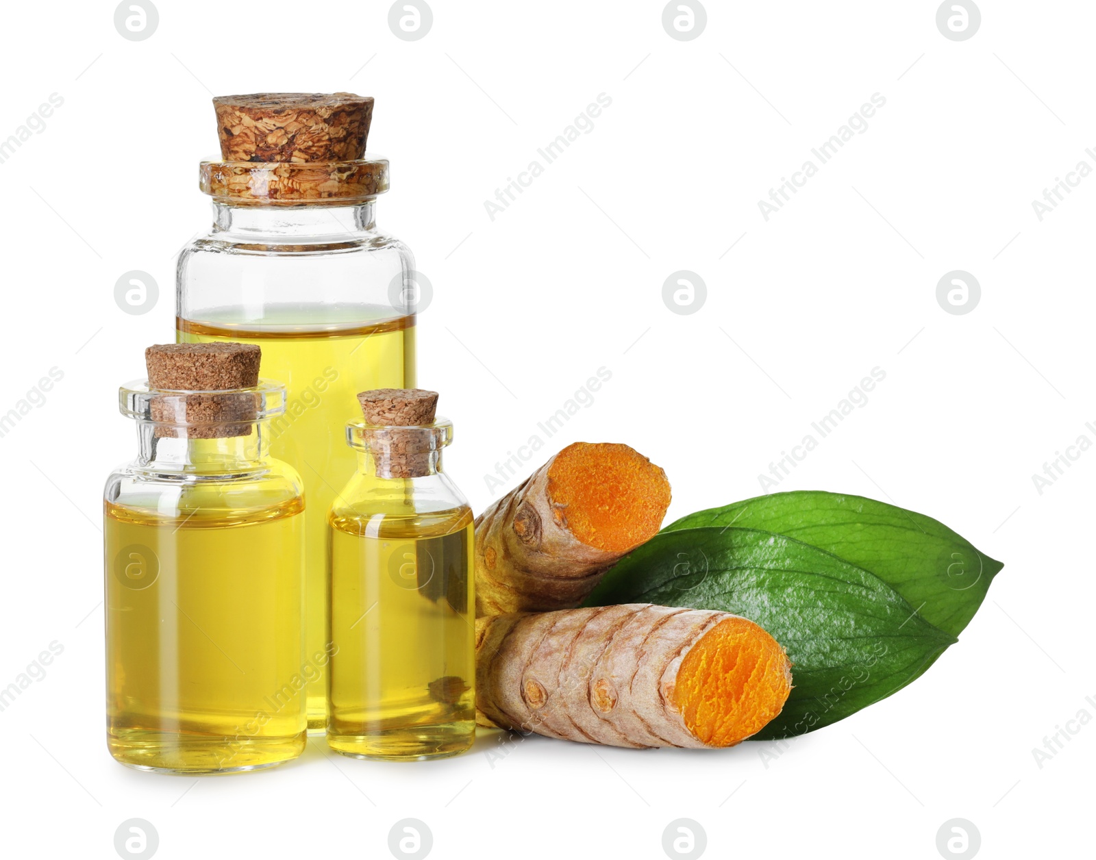 Photo of Bottles of turmeric essential oil, raw roots and leaves isolated on white