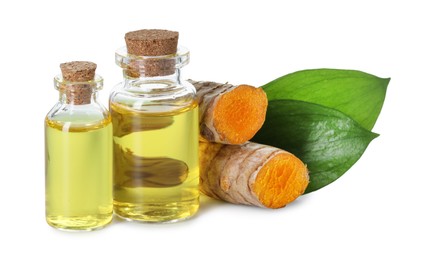 Photo of Bottles of turmeric essential oil, raw roots and leaves isolated on white