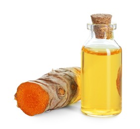 Photo of Bottle of turmeric essential oil and raw root isolated on white