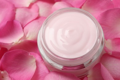 Jar of cream on pink petals, closeup