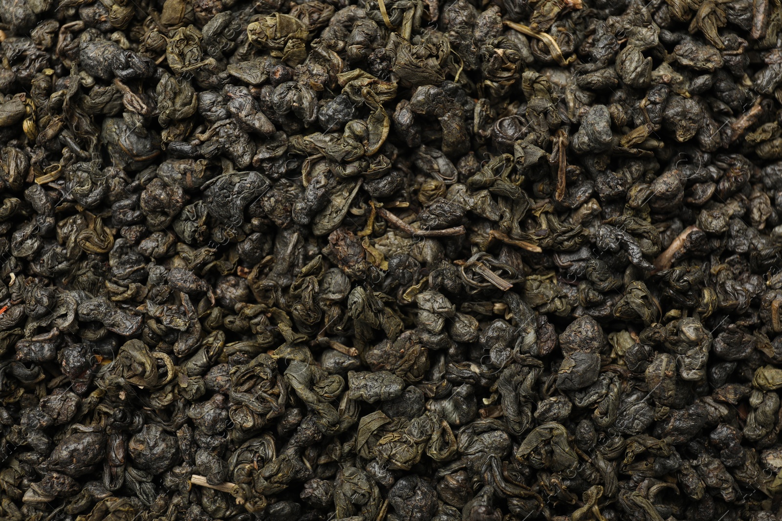 Photo of Pile of dry tea leaves as background, top view