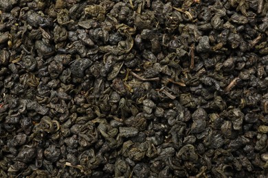 Photo of Pile of dry tea leaves as background, top view