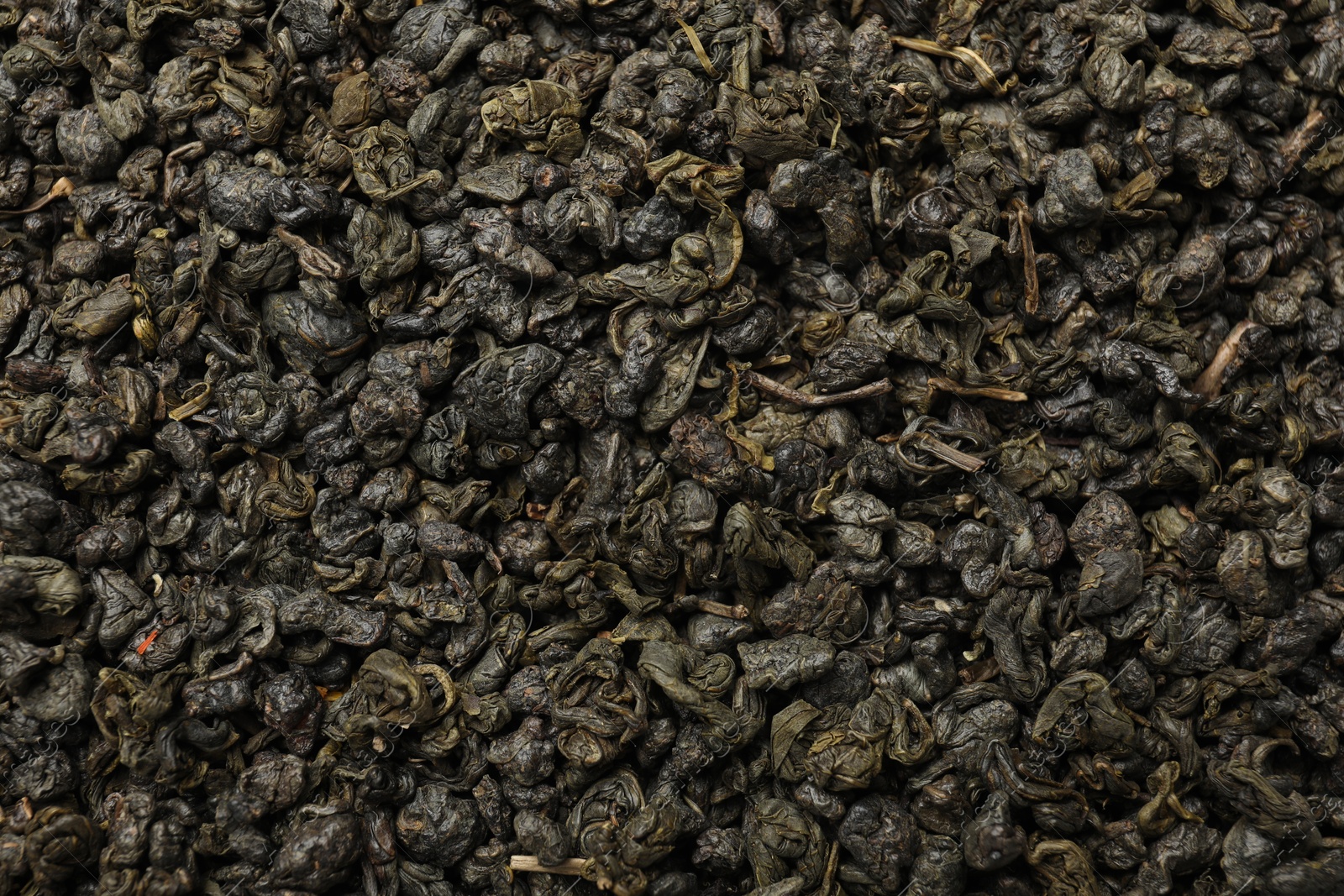 Photo of Pile of dry tea leaves as background, top view