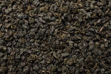 Photo of Pile of dry tea leaves as background, top view