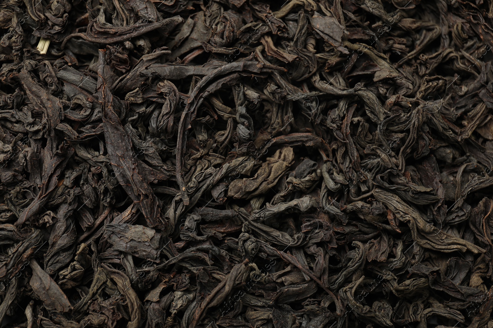 Photo of Pile of dry tea leaves as background, top view