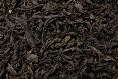 Photo of Pile of dry tea leaves as background, top view