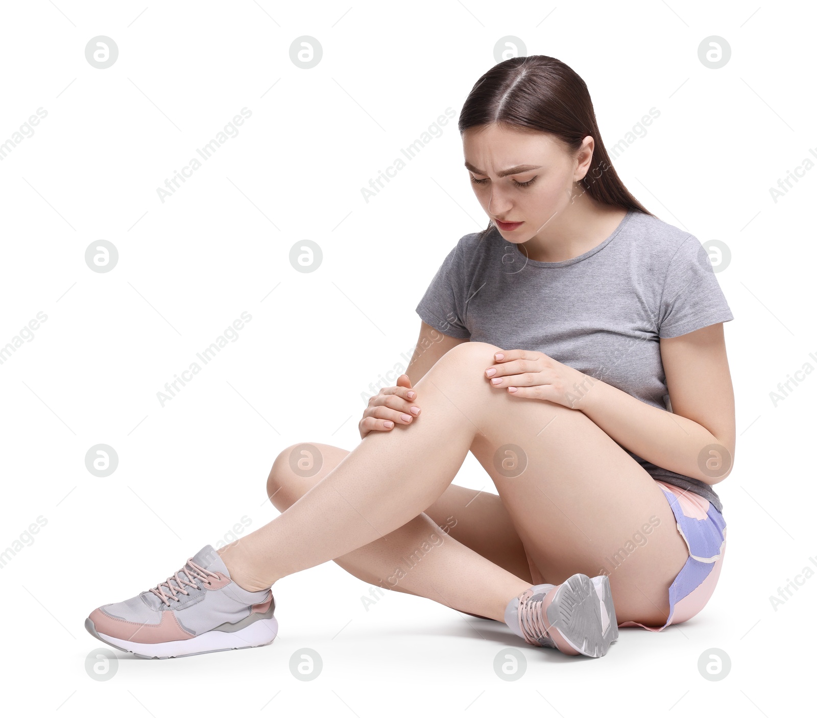 Photo of Young woman suffering from pain in knee on white background