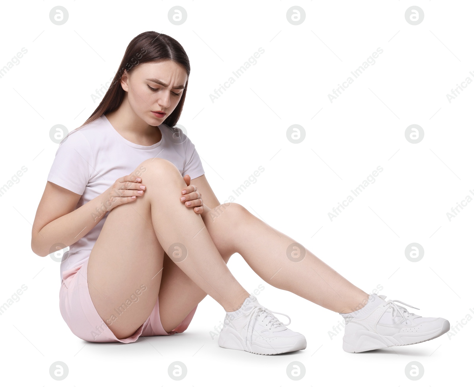 Photo of Young woman suffering from pain in knee on white background