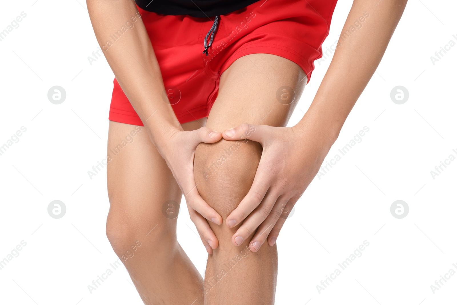 Photo of Young man suffering from pain in knee on white background, closeup