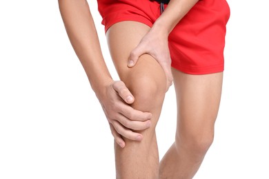 Photo of Young man suffering from pain in knee on white background, closeup