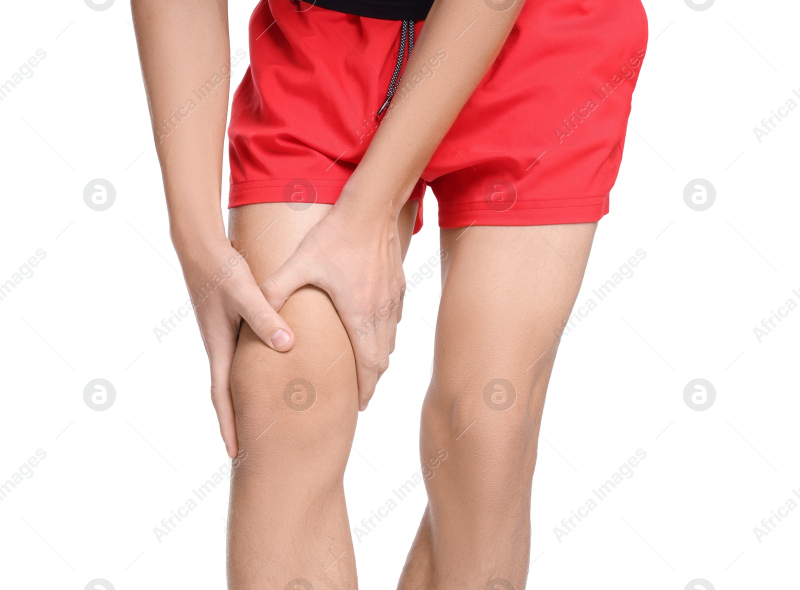 Photo of Young man suffering from pain in knee on white background, closeup