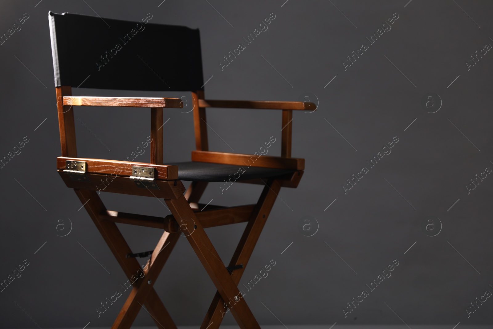 Photo of One empty director's chair on grey background, closeup. Space for text