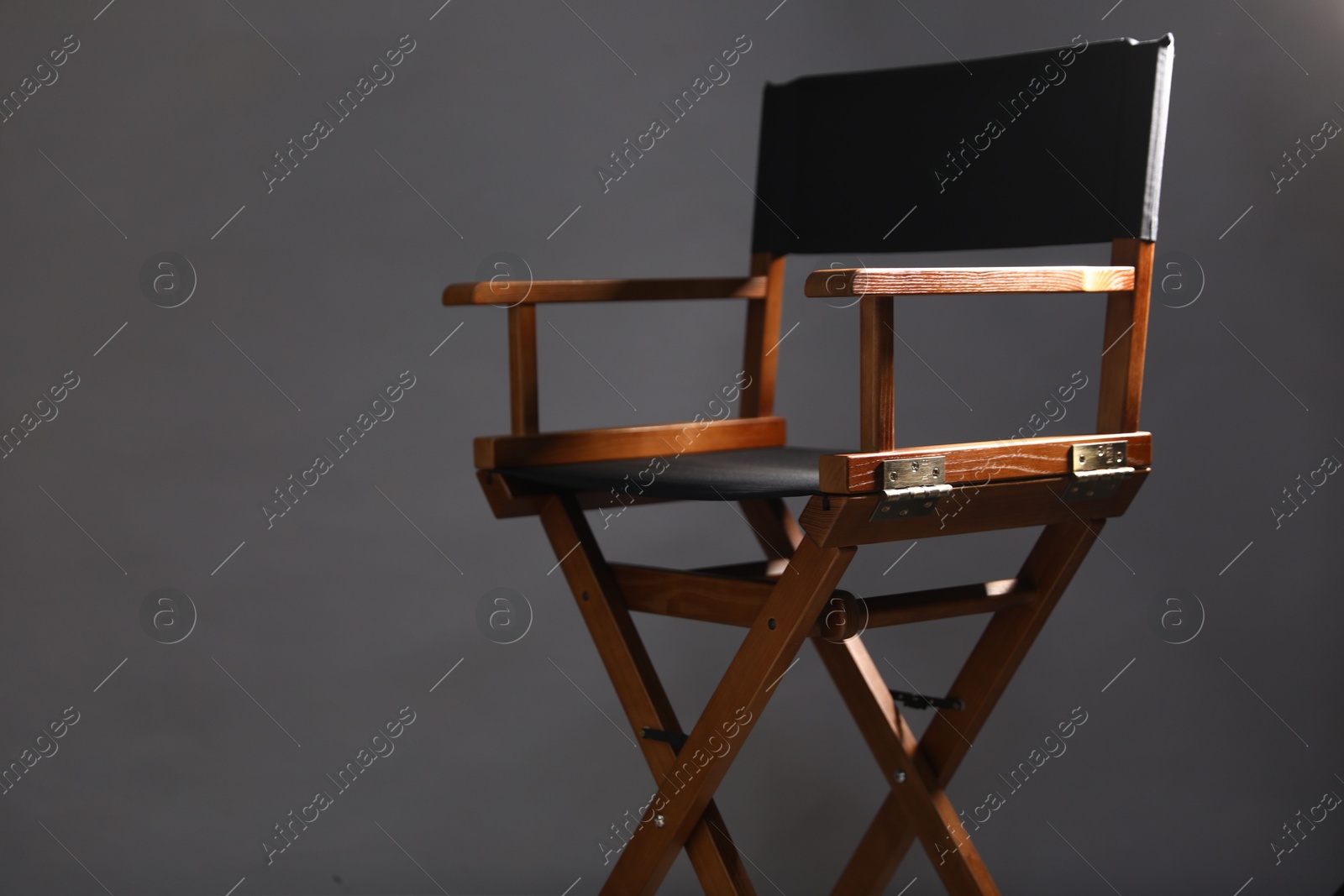 Photo of One empty director's chair on grey background, closeup. Space for text