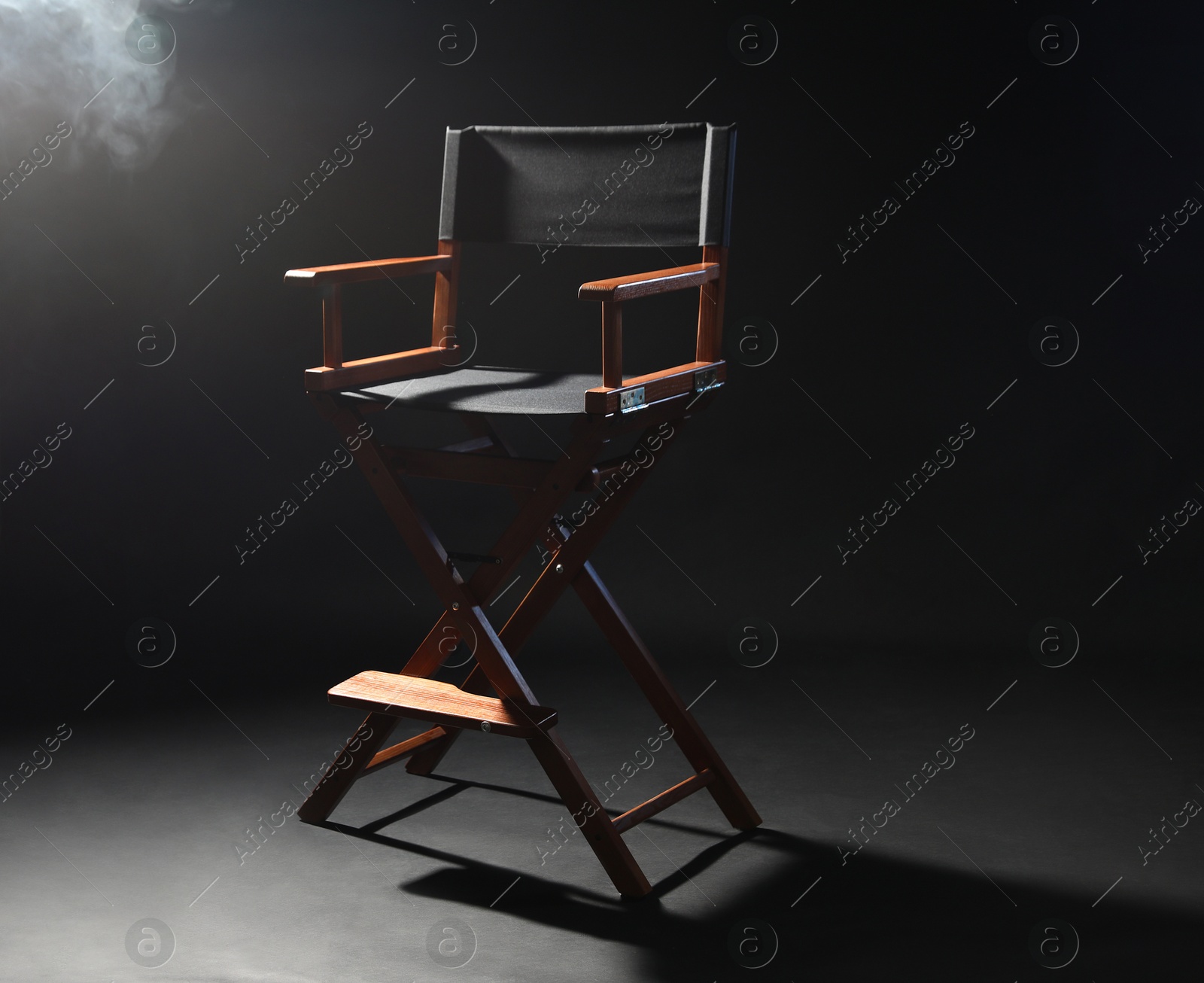 Photo of One empty director's chair on black background with smoke