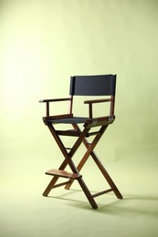 Photo of One empty director's chair on pale olive background