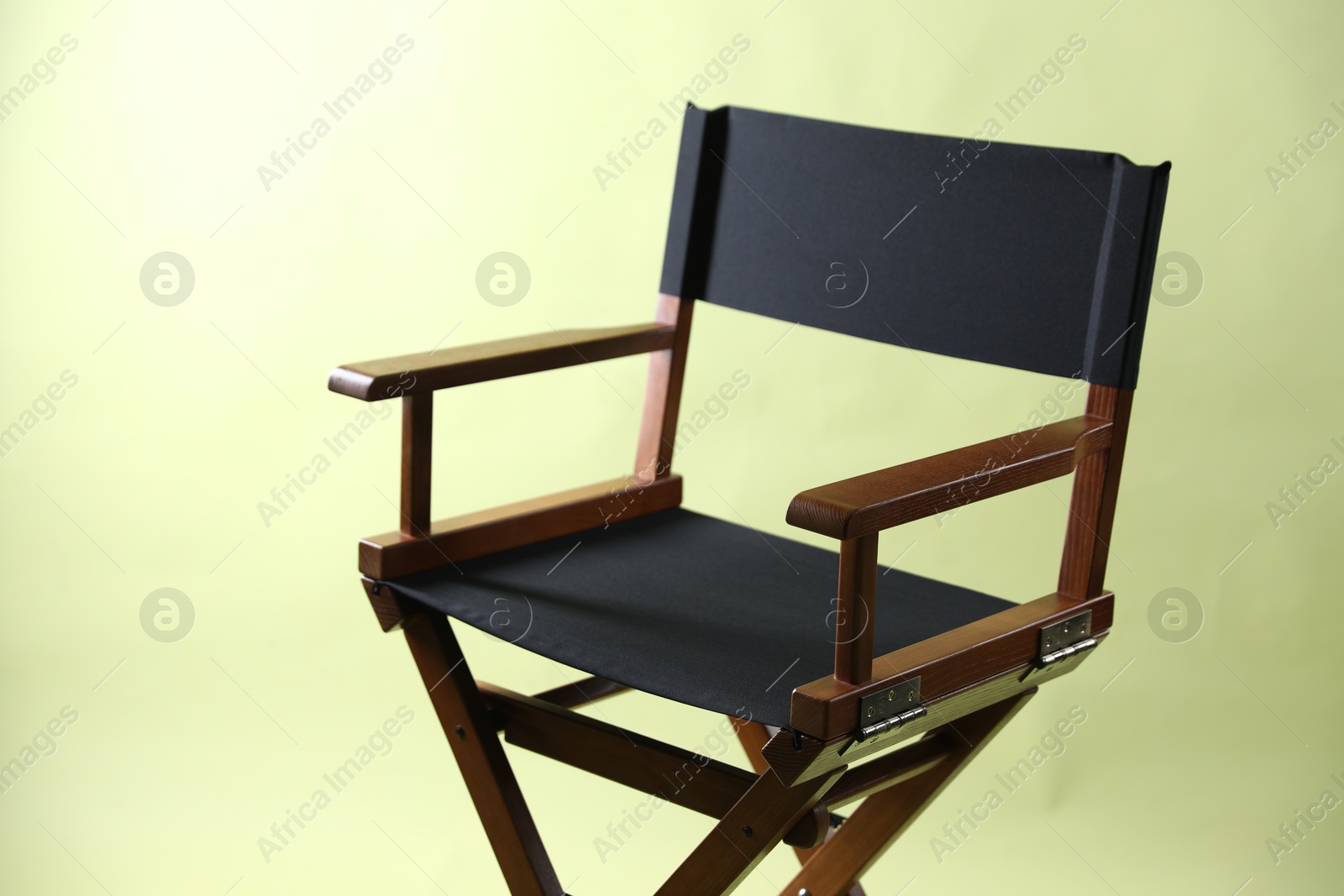 Photo of One empty director's chair on pale olive background, closeup