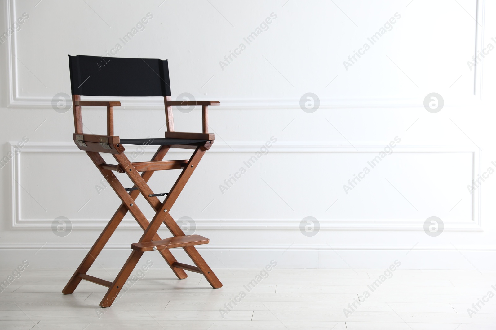 Photo of One empty director's chair near white wall indoors, space for text