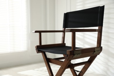 Photo of One empty director's chair indoors, closeup. Space for text