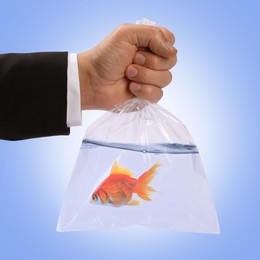 Man holding plastic bag with fish and water on light blue background, closeup