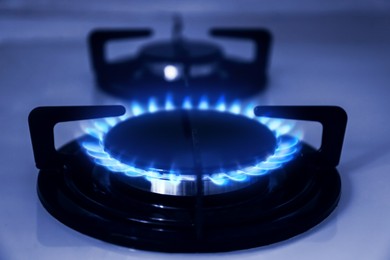 Image of Gas burner with blue flame on stove, closeup