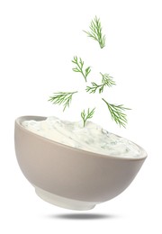 Image of Fresh green dill falling into bowl of sauce on white background