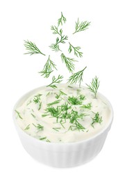 Image of Fresh green dill falling into bowl of sauce on white background