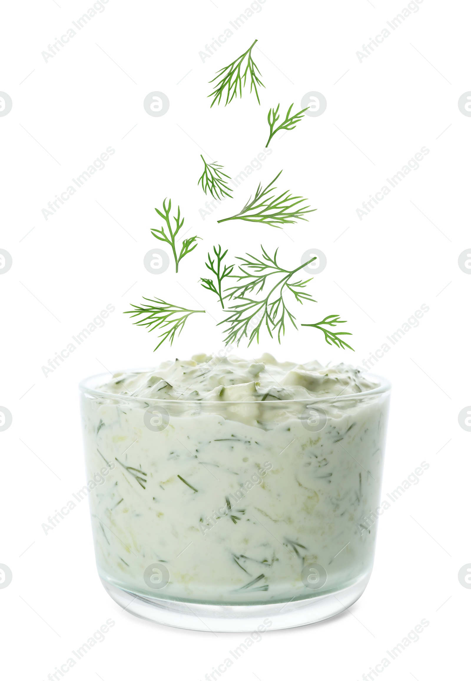 Image of Fresh green dill falling into bowl of sauce on white background