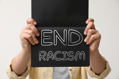 Image of Woman holding notebook with text End Racism on white background, closeup