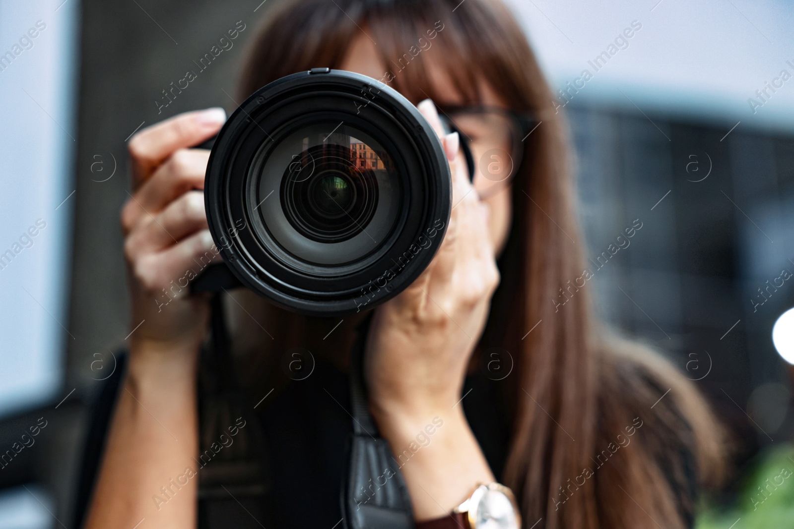 Photo of Professional photographer taking picture with camera outdoors, selective focus