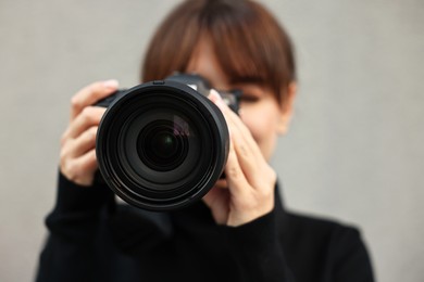 Photo of Professional photographer taking picture with camera outdoors, selective focus