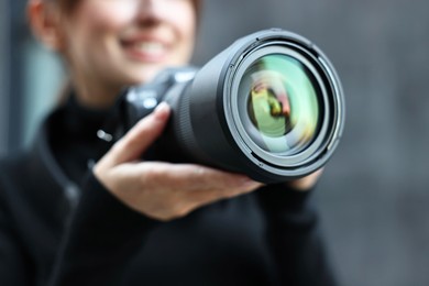 Photo of Professional photographer taking picture with camera outdoors, closeup