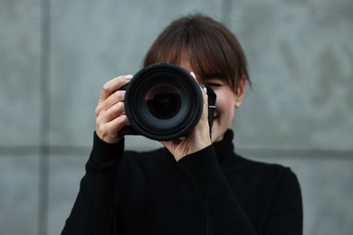 Photo of Professional photographer taking picture with camera outdoors, selective focus