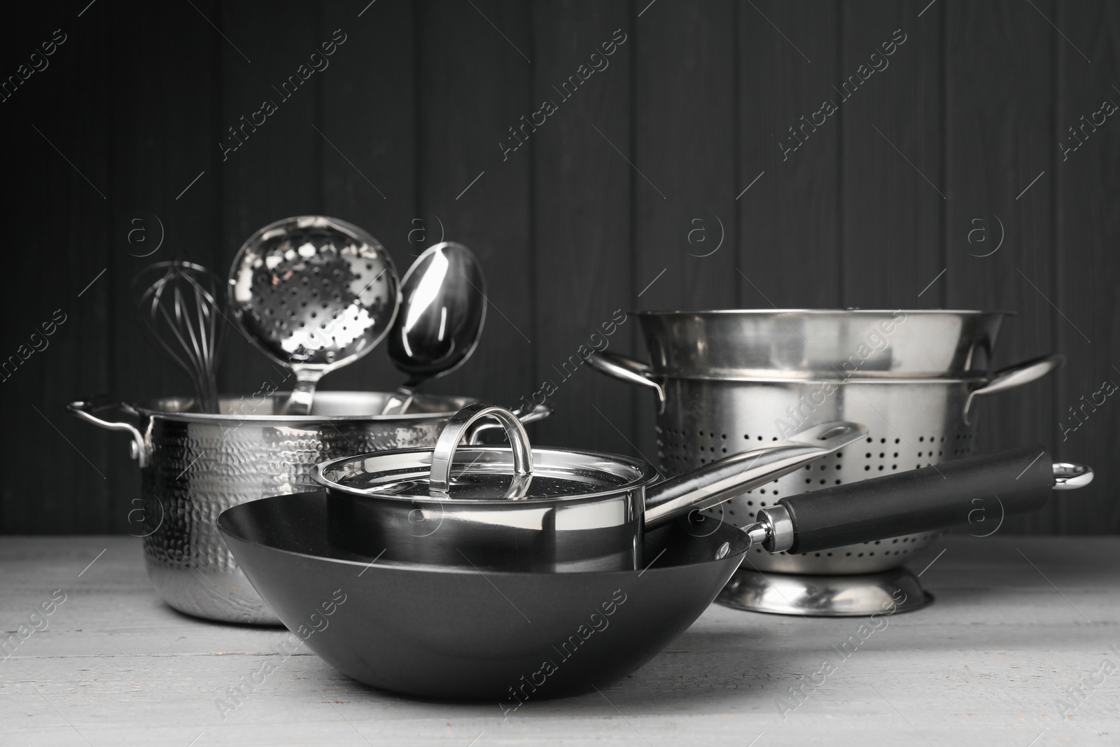 Photo of Dishware and cooking utensils on grey wooden table