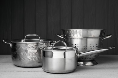 Photo of Stainless steel dishware on grey wooden table