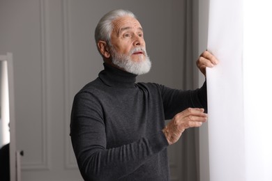 Photo of Portrait of handsome bearded man near window indoors