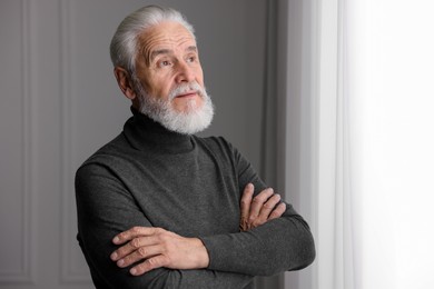 Photo of Portrait of handsome bearded man near window indoors